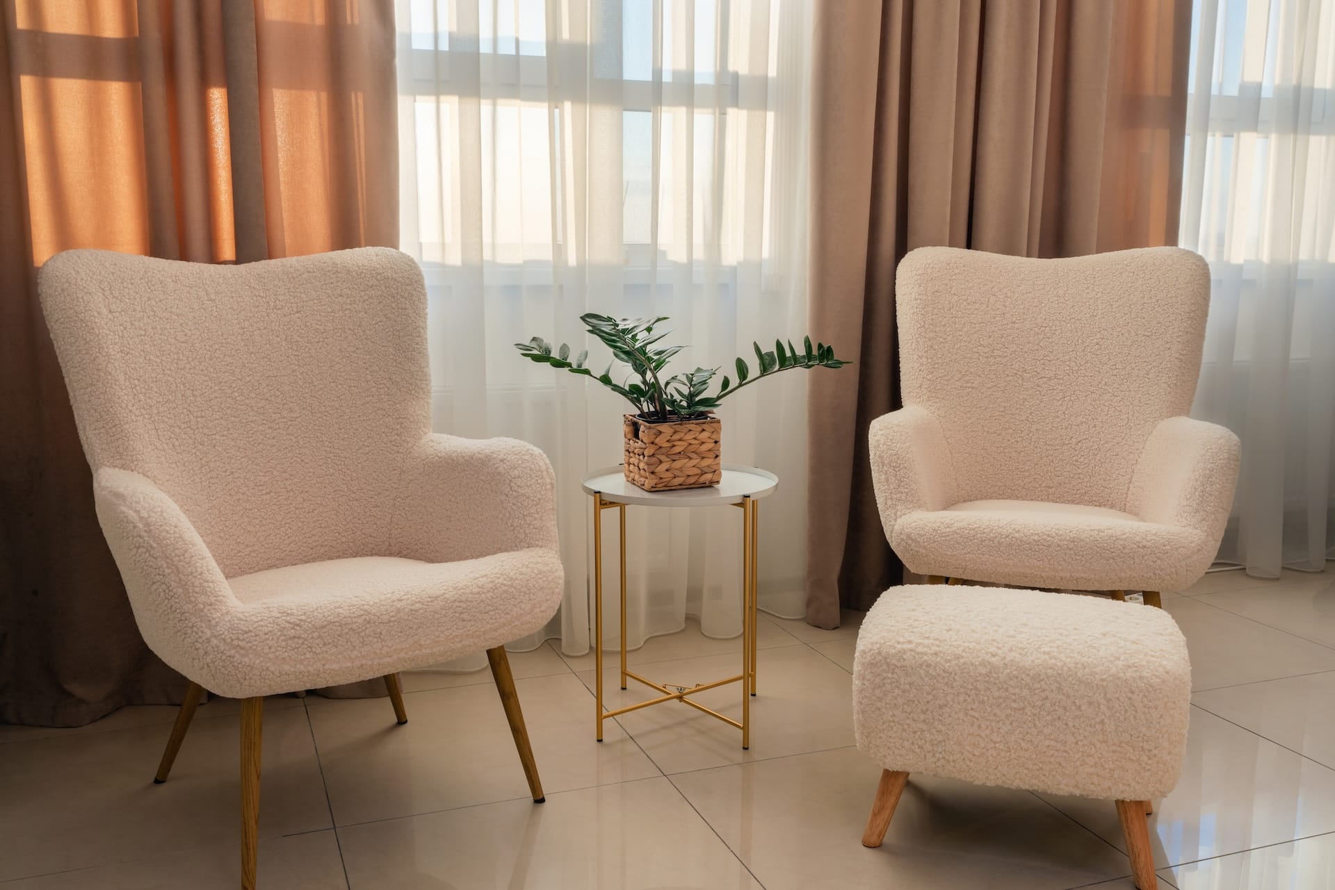 Elegant armchairs standing near a coffee table with a houseplant in the living room.